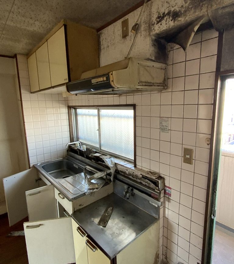 経年劣化で汚れの目立つキッチン。ガスコンロも別途設置が必要なブロックタイプ